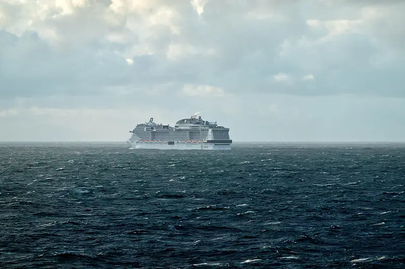Cruise ship on the open sea under a cloudy sky